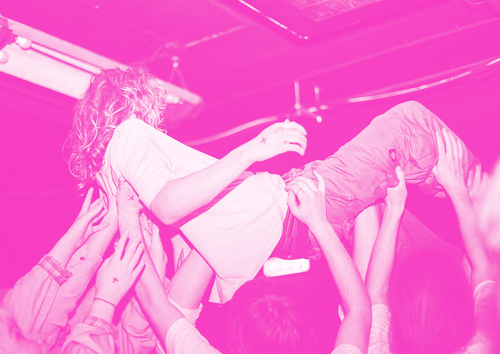 pink tinted photograph of crowd surfing by birmingham city student