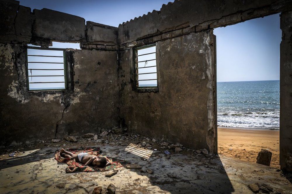 Environmental Photographer of the Year 2021 was won by this image - The Rising Tide Sons by Antonio Aragon Renuncio. It shows a child sleeping inside a house destroyed by coastal erosion on Afiadenyigba beach in Ghana