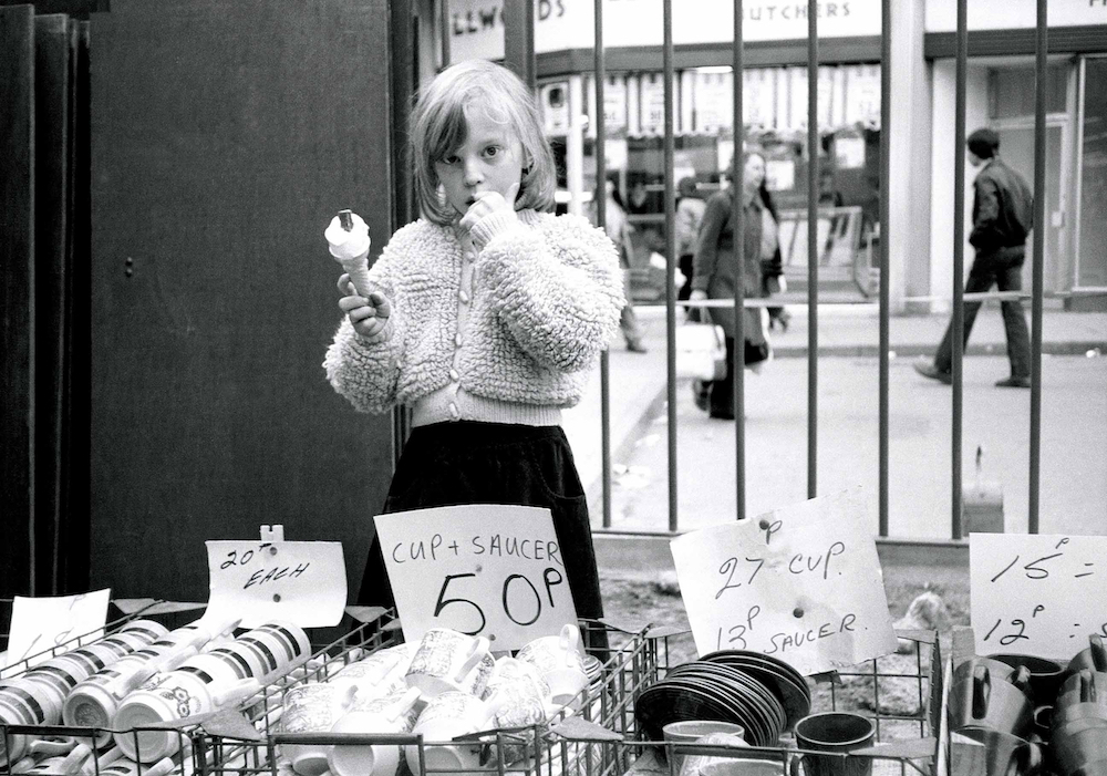 Flake, ice cream and crockery - six-year-old Alli Winter at Peterborough market, 1983. © Chris Porsz