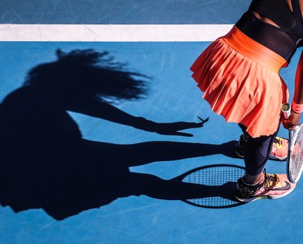 Japan's Naomi Osaka removes a butterfly from her dress as she plays against Tunisia's Ons Jabeur during their women's singles match on day five of the Australian Open tennis tournament in Melbourne on 12 February 2021. © David Gray
