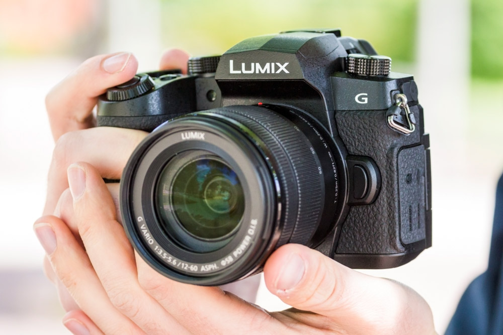 The best Panasonic cameras: Panasonic Lumix G90 with 12-60mm lens in hand