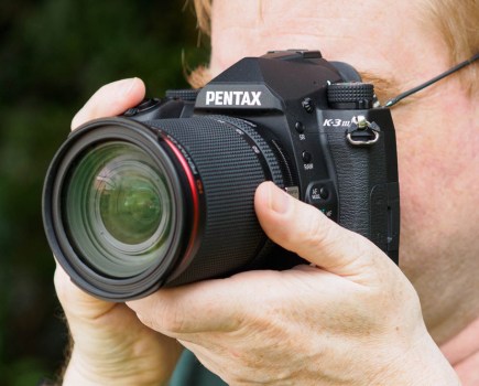 Pentax K-3 III, DSLR in hand with lens