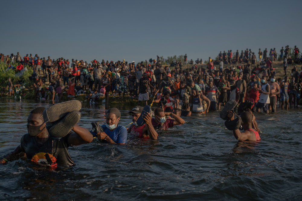 Hundreds of migrants cross the river from Del Rio, Texas, to Ciudad Acuña, Coahuila, Mexico, to buy food and supplies before returning to the US on 20 September 2021. In mid-September, approximately 15,000 migrants converged under a bridge at the U.S.-Mexico border, in Del Rio. Many were Haitians who had left Haiti for countries in Latin America years ago. © Victoria Razo/LOBA 2022 