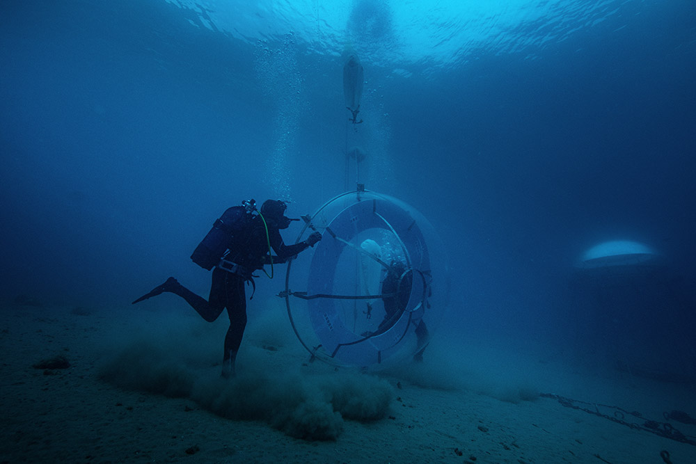 scubadivers submerging the underwater greenhouses 