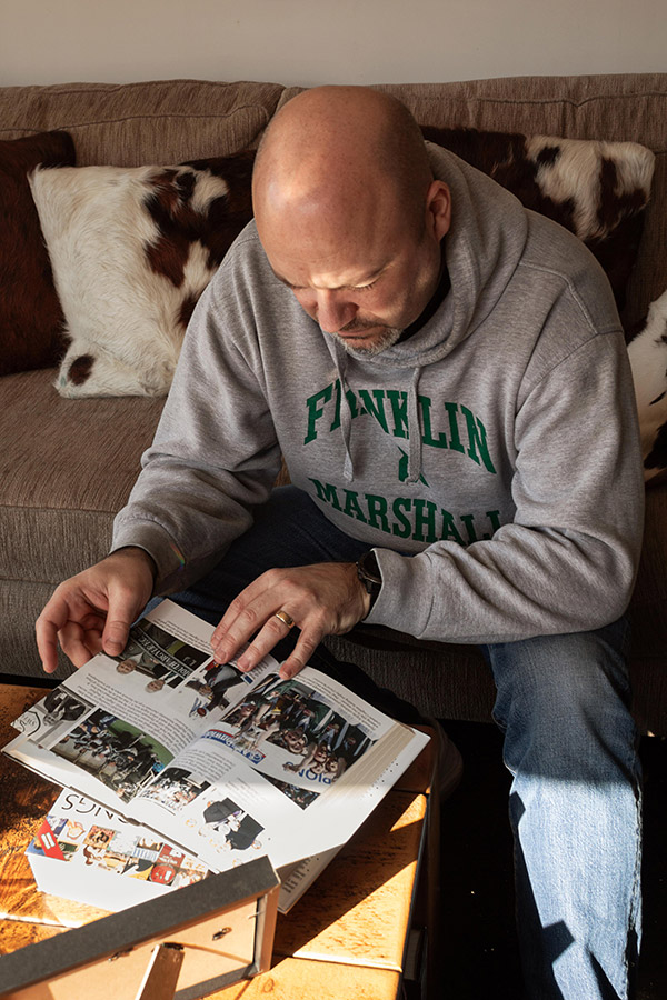 the dad of middlesex graduate renee gordon looking through an old football book