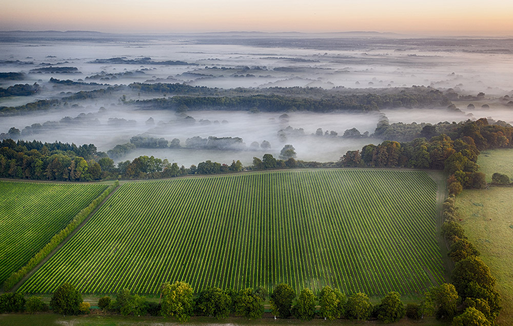 drone looking over countryside landscape with mist on the horizon