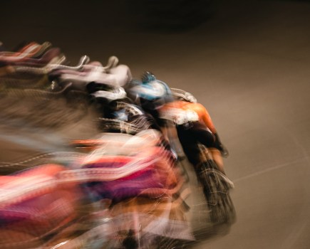a blurred image of cyclists racing around a veldrome stadium london institute of photography