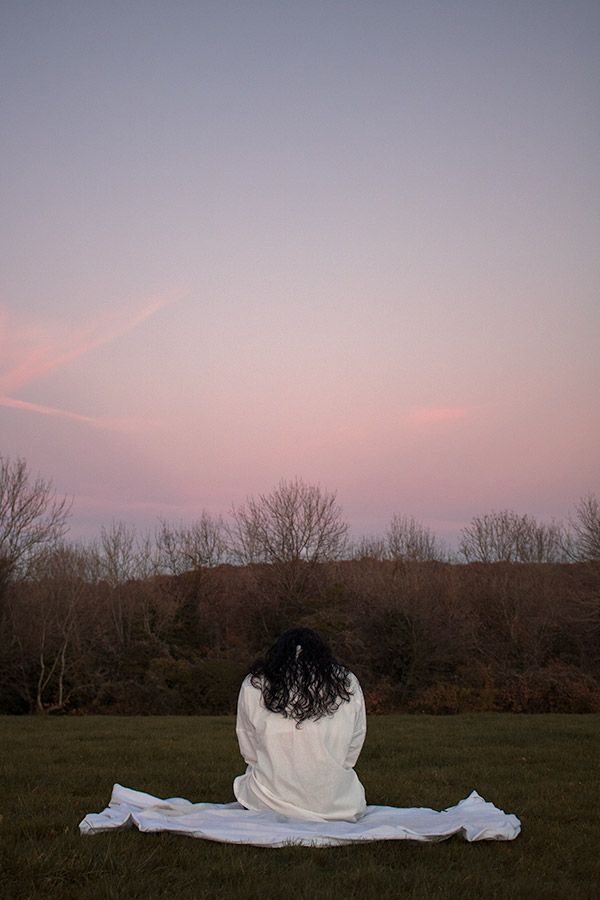 girl sat at sunset on a white blanket by westminster graduate