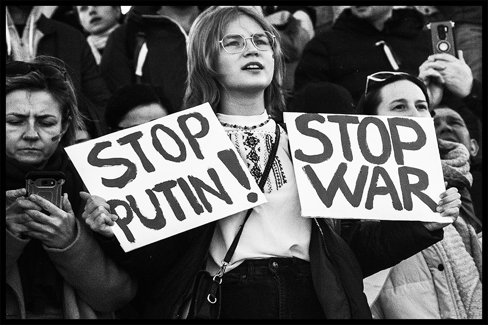 young girl holding stop war stop putin signs at protest