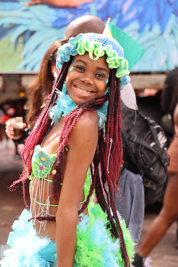 girl in green carnival outfit smiles at camera