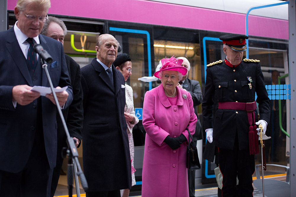 Queen Elizabeth II and The Duke of Edinburgh during a 2015 visit to Birmingham, England, to launch the city’s tram system. © Denise Maxwell/Lensi Photography.