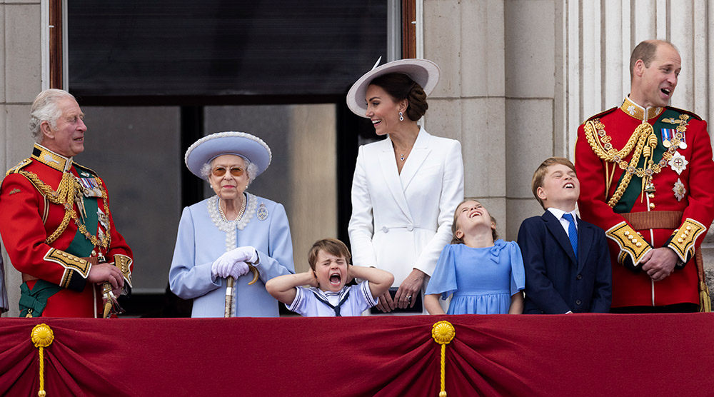 The Platinum Jubilee, London, shot from the Queen Victoria Memorial. HM Queen Elizabeth II looks on ahead during the Red Arrows flypast, while a young member of the royals, Prince Louis, screams and covers his ears, 2 June 2022. © Humphrey Nemar/Reach PLC.