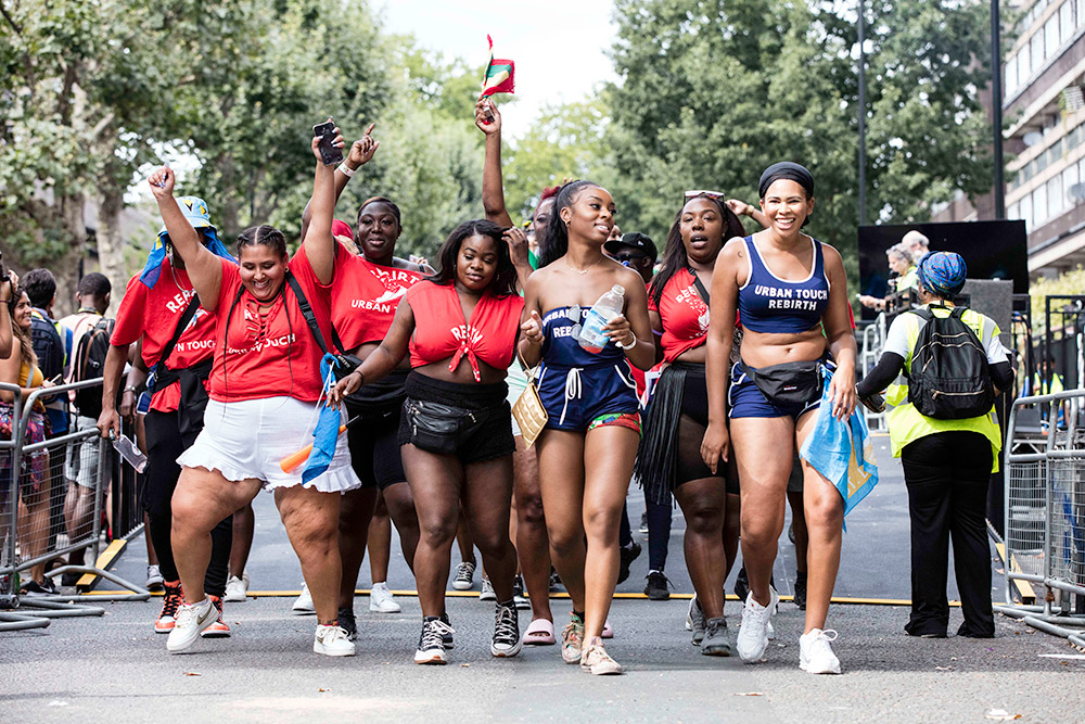 group of friends dancing down the road of notting hill carnival