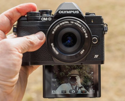 Olympus OM-D E-M10 Mark IV in hand, with selfie screen