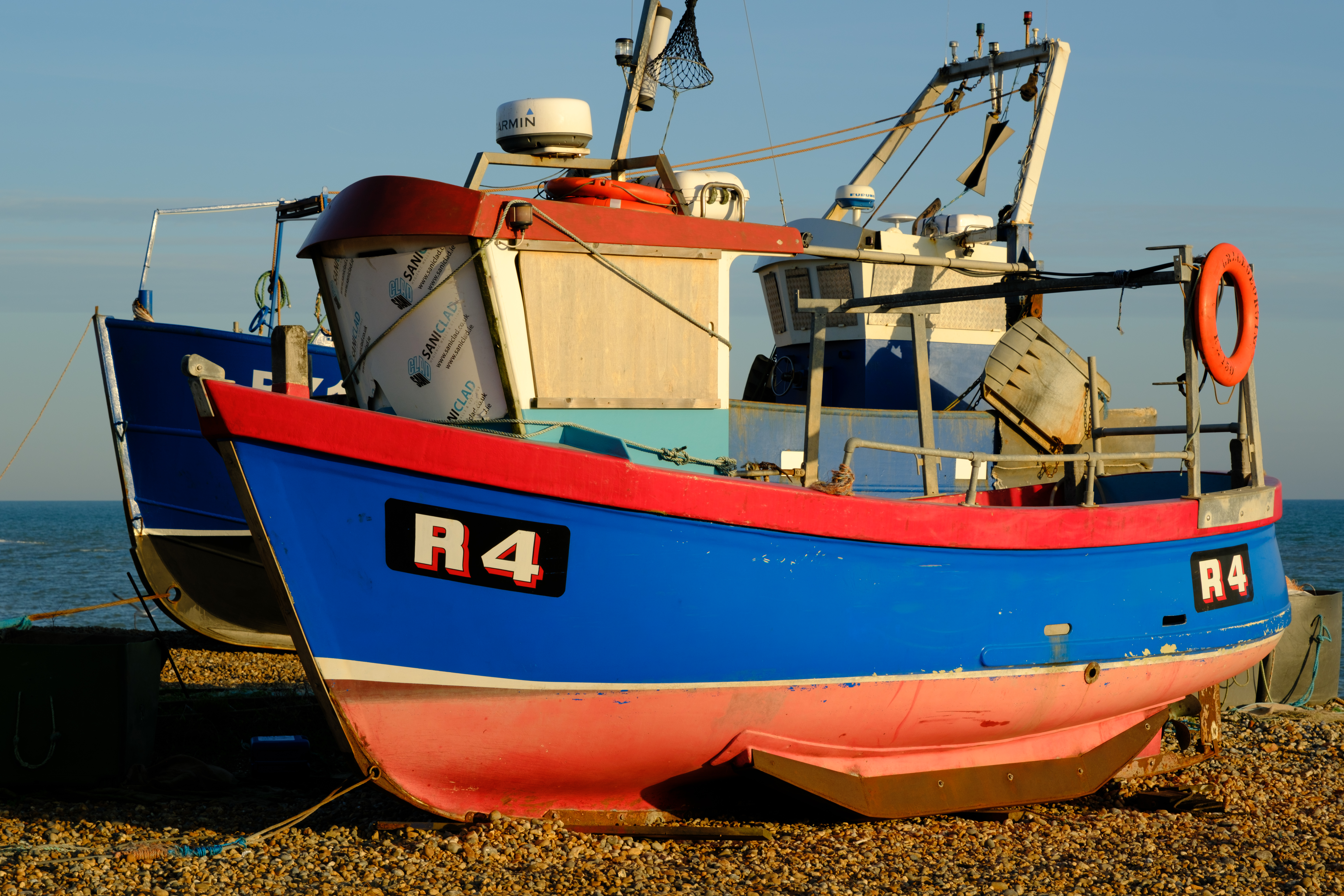 Fujifilm X-T5 sample image, two red and blue small fishing boat on the shore, 