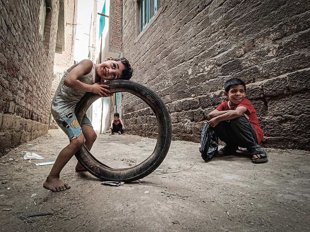 young boys playing in the street with tyres