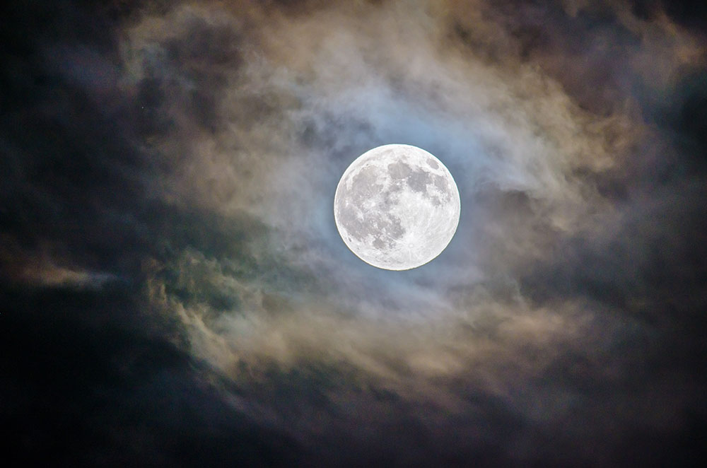 Full moon through clouds.
