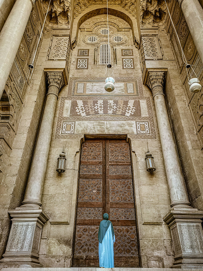 woman wearing blue standing infront of islamic architecture travel apoy 2023