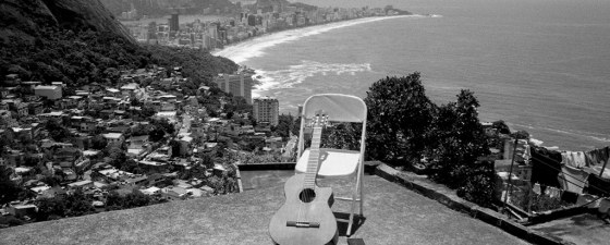 A guitar rests on an empty chair with the skyline of Rio de Janeiro in the background. Leica Gallery London to showcase Andy Summers photos