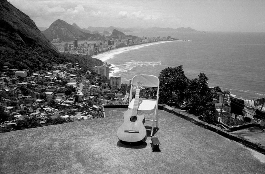 A guitar rests on an empty chair with the skyline of Rio de Janeiro in the background. Leica Gallery London to showcase Andy Summers photos