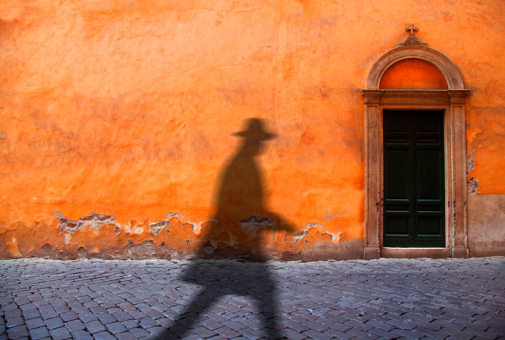 silhouette on against orange wall on rome street, best cities