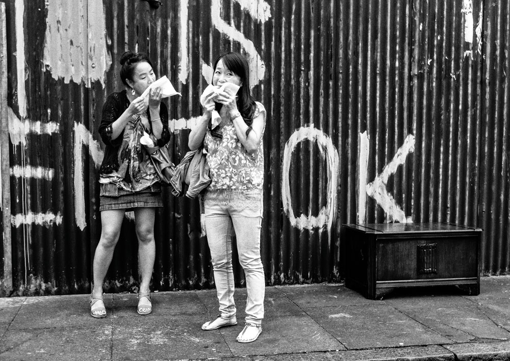 women eating takeaway food on the street
