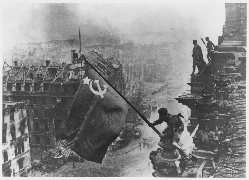 Flying The FlagRussian soldiers flying the Red Flag, made from table cloths, over the ruins of the Reichstag in Berlin. (Photo by Yevgeny Khaldei/Getty Images) photo hoaxes