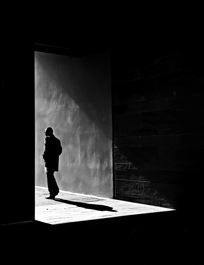 person walking into light from dark sheet 