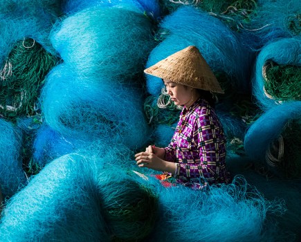 vietnamese lady Mending fishing nets travel round apoy 2023