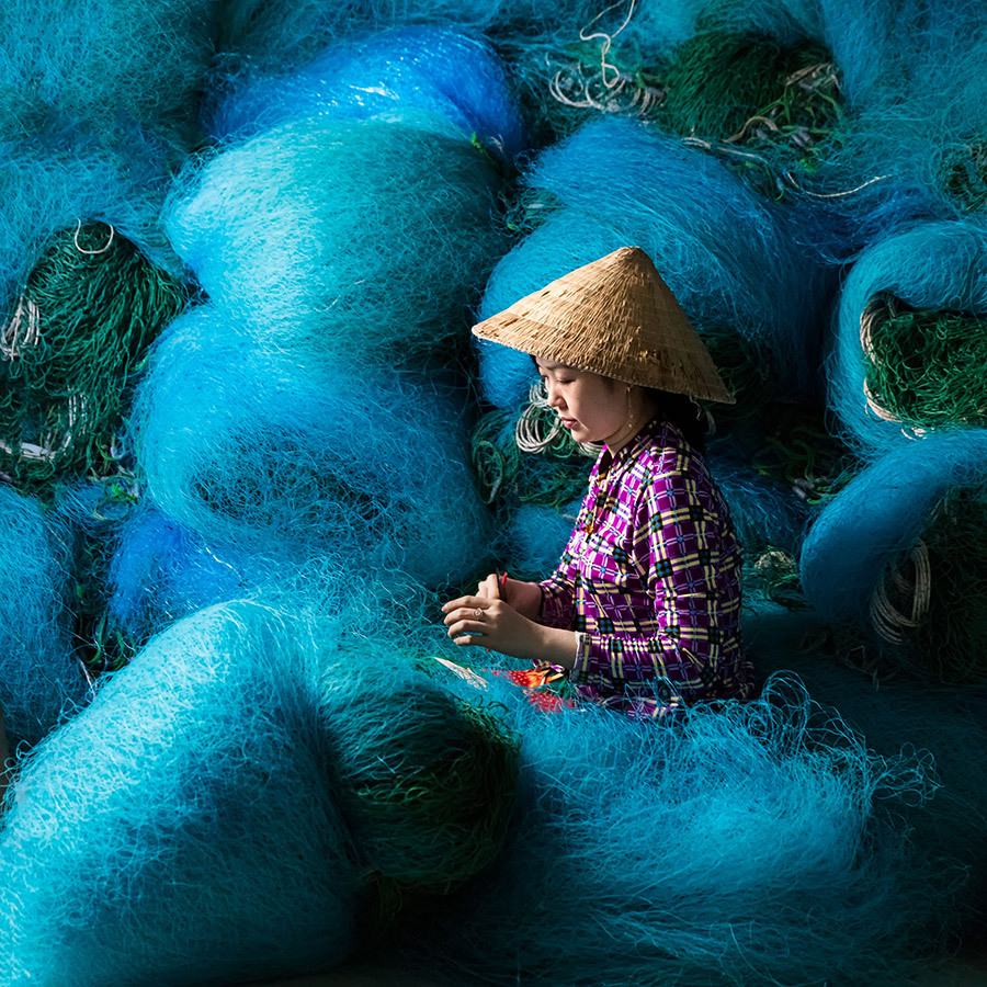 vietnamese lady Mending fishing nets travel round apoy 2023