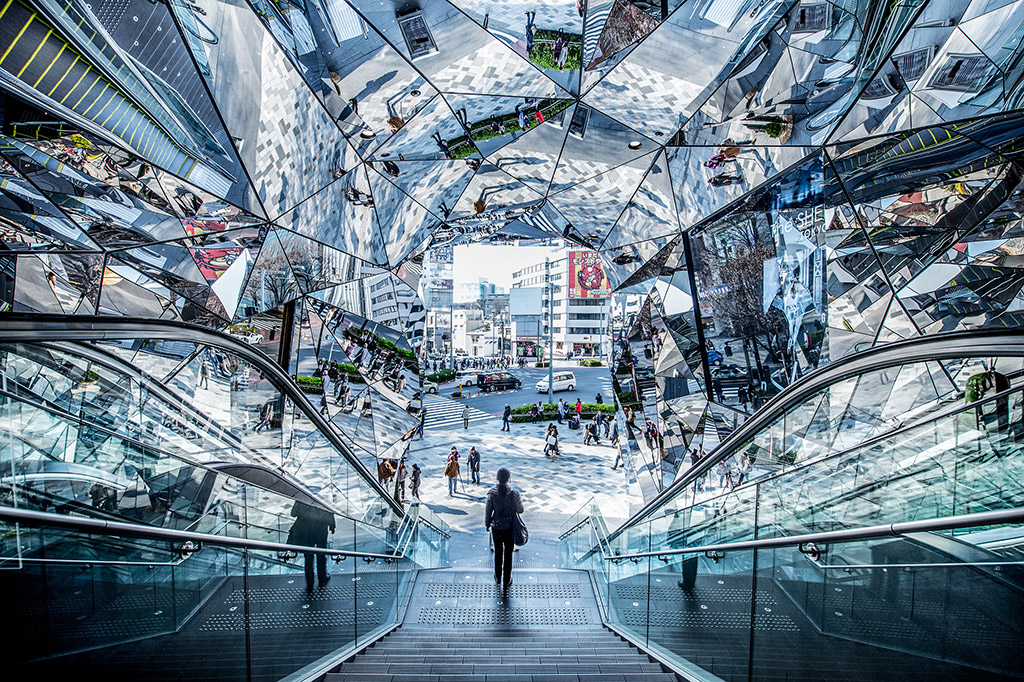person walking down steps inside geometric building with reflections Tokyu Plaza, Harajuku, Tokyo, Japan