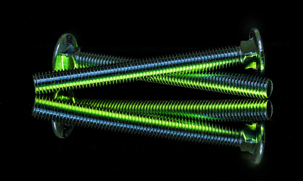skillfully lit image of some simple screws green light
