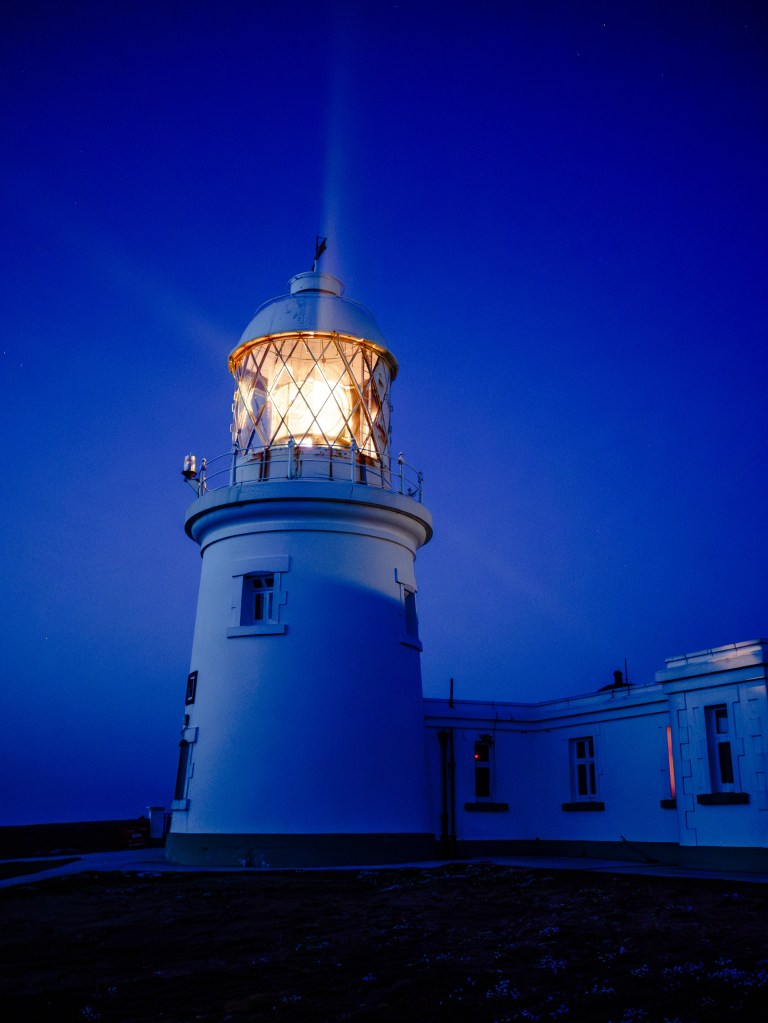 This handheld low-light shot shows the difference between IBIS and ISO. I could have used a lower ISO and relied on the camera's in-body stabilization to keep the lighthouse sharp. The quality would have been better but the lantern would have been blurred and the beams of light would have disappeared. To capture this moving subject, the only solution was a higher ISO to allow a shorter exposure. Photo: Rod Lawton