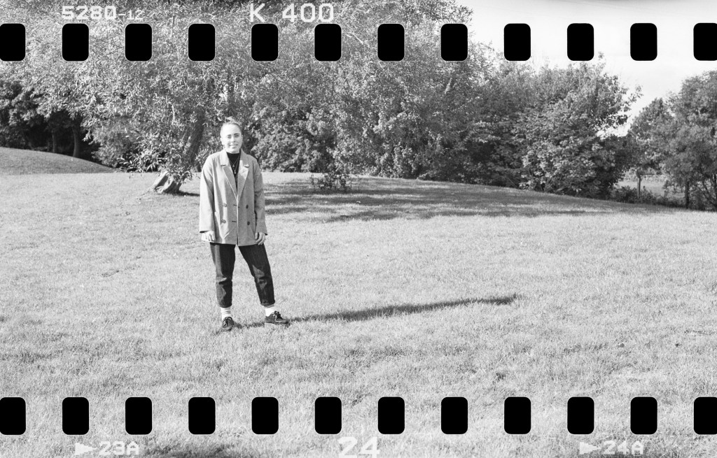 Sprocket photography, black and white full body portrait of a woman standing in a park