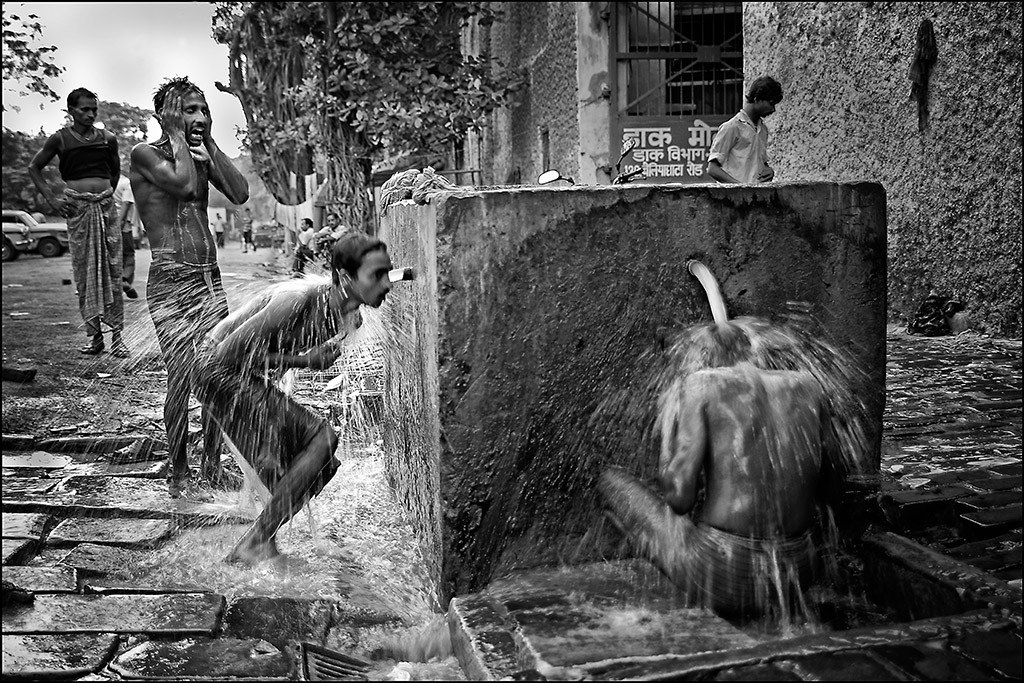 Kolkata (Calcutta), West Bengal, India. Washing in the street is quite usual in the suburbs of a city where, a couple of miles from the centre, people have no running water in their homes. © Ian Berry