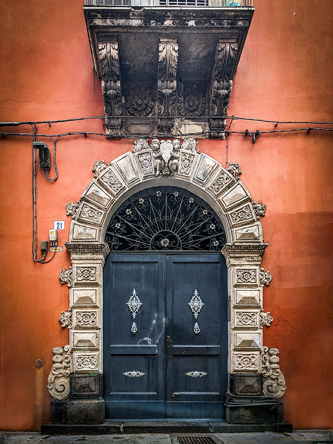 grand doors to orange building in catania italy