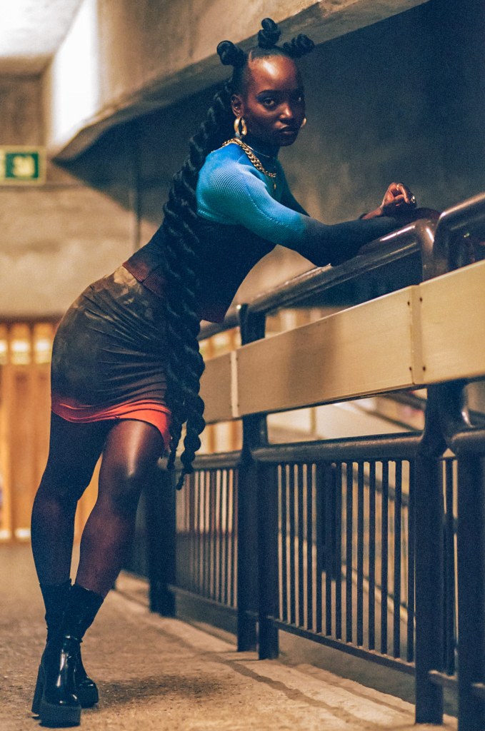 Girl leaning over a railing wearing a black red and blue outfit