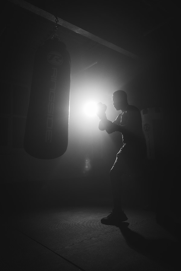 person boxing with a bag silhouette with backlighting photography graduate