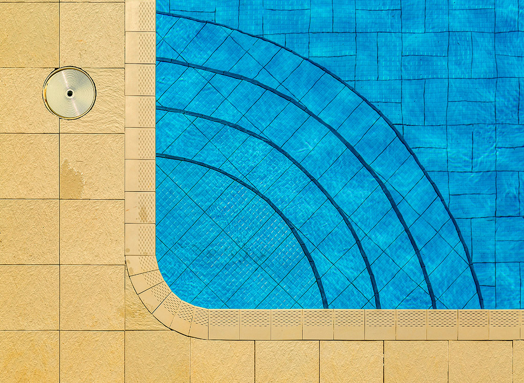 looking down on the corner of a swimming pool with rounded steps