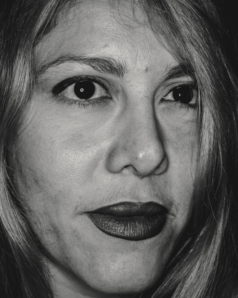 Close up black and white analogue portrait shot of a woman in her 40s with dark lipstick