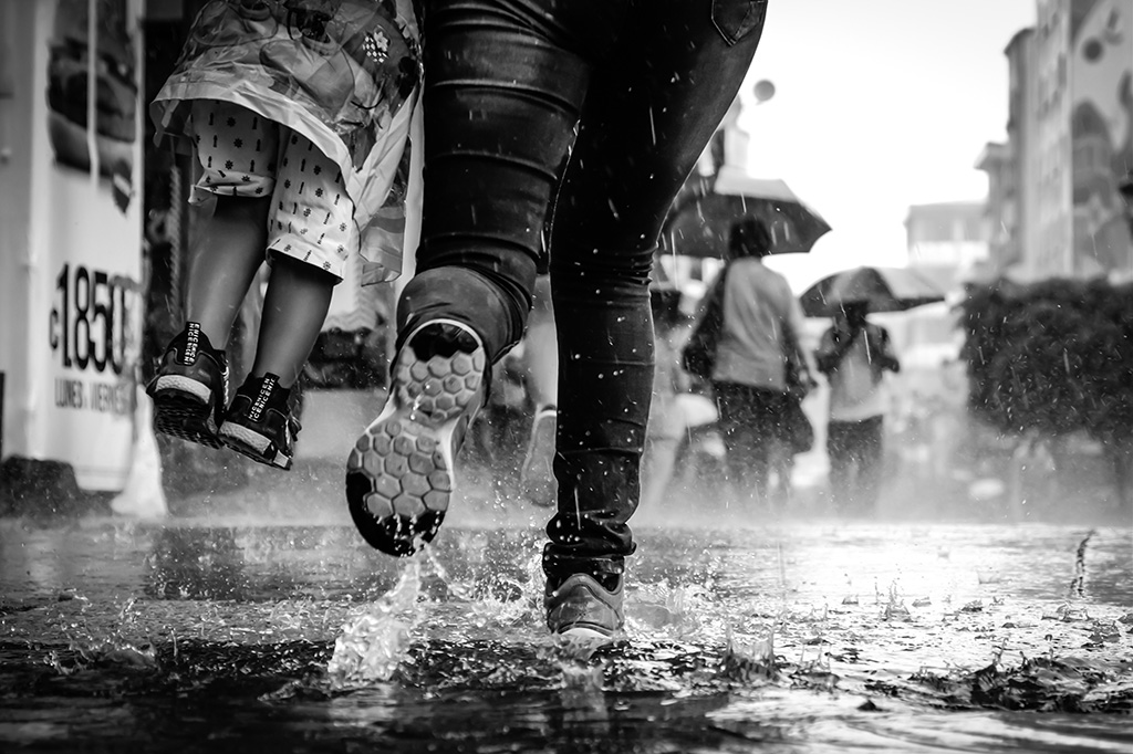 people running through heavy rain close up of feet and water