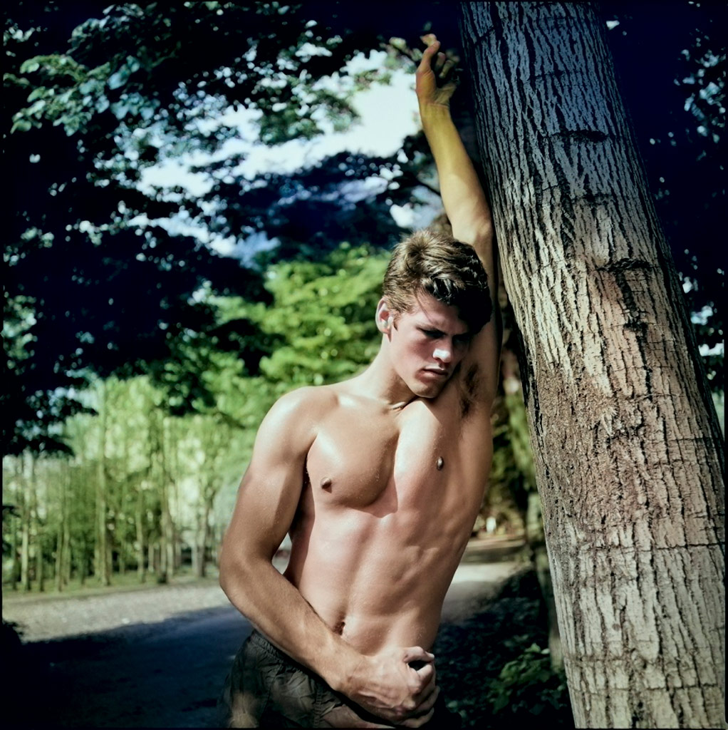 A young man in trousers leaning against a tree, Photoshop AI colouring example