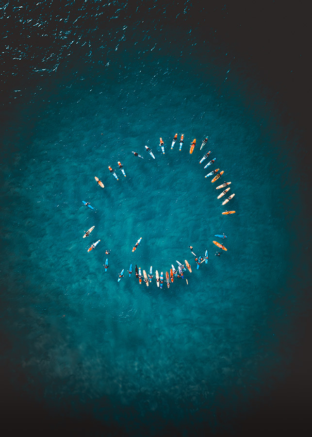 birds eye view of surfers in a circle in the water