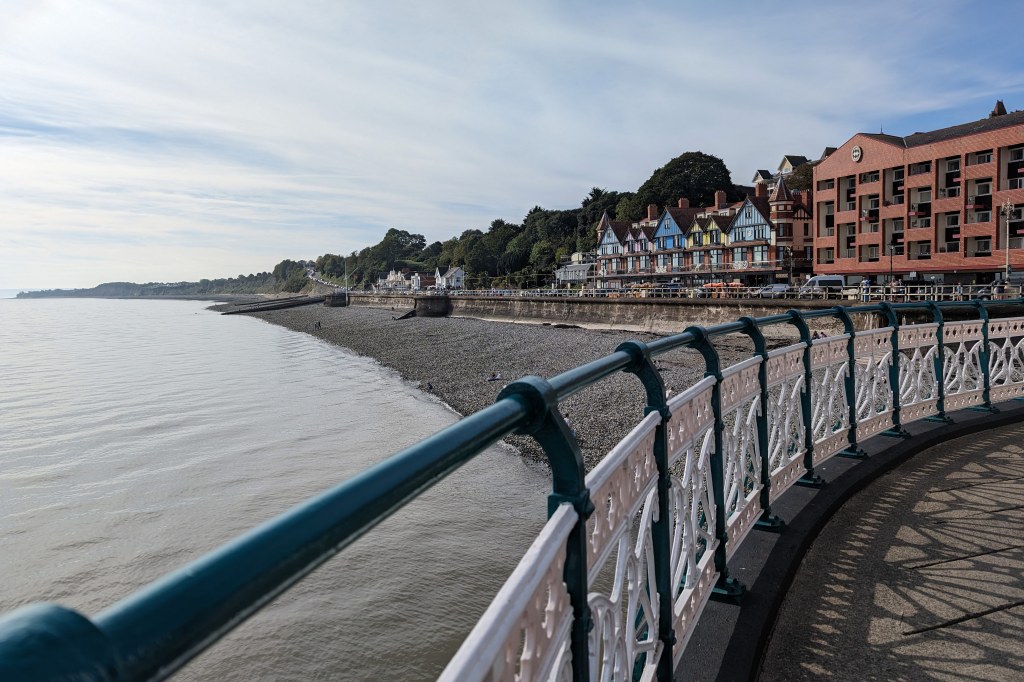 GooglePixel 8 Pro sample image, railings next to a pebbly beach, a line of houses next to the sea