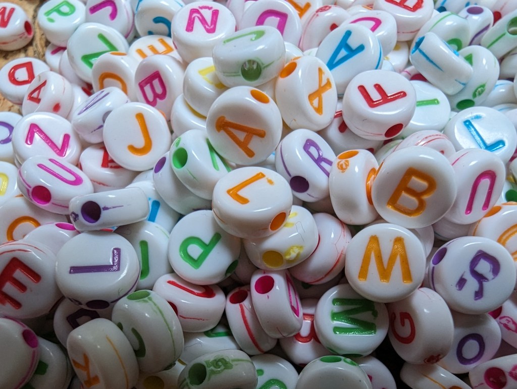 Google pixel 7 Pro macro sample image, white beads with colourful letters on them
