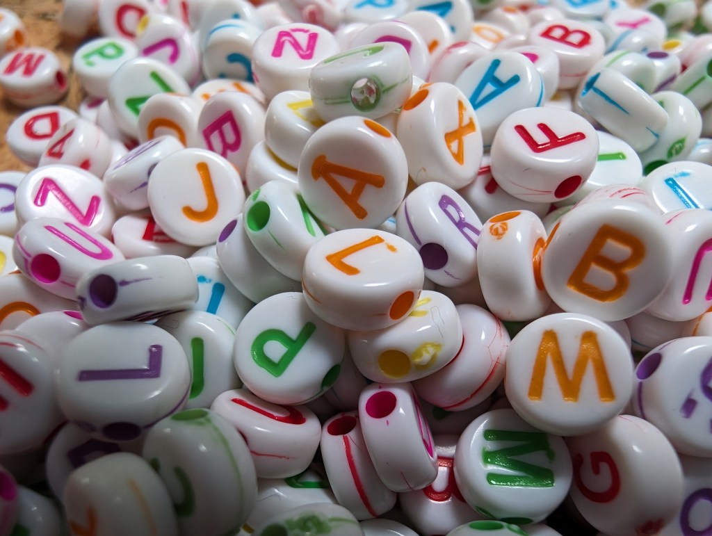 Google Pixel 8 Pro Macro Sample image of white beads with colourful letters on them