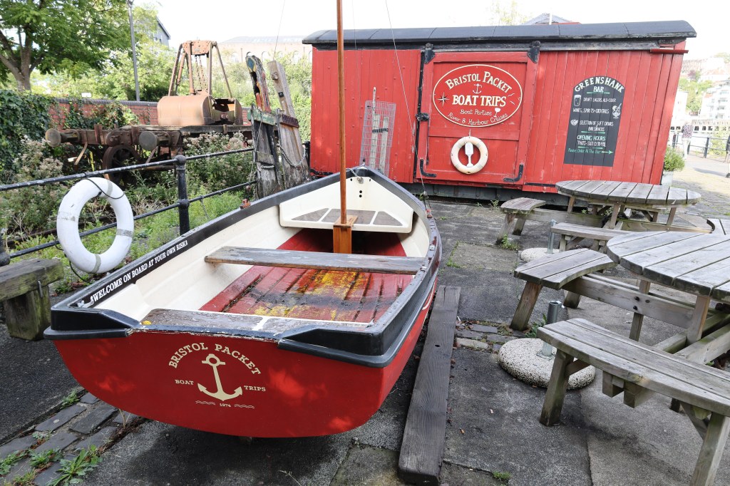 Canon RF 24-105 mm F4-7.1 IS STM lens sample image, a red wagon and a small red boat with the sign "Bristol Packett Boat Trips" written on them