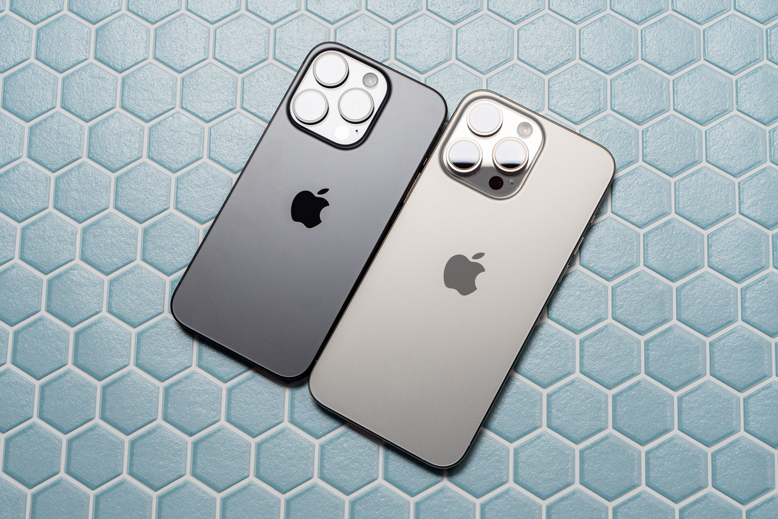 The iPhone 15 Pro and iPhone 15 Pro Max in Black Titanium (left) and Natural Titanium (right)