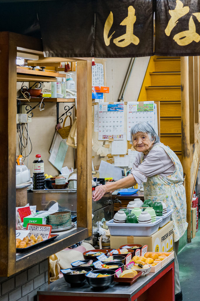 elderly Japanese lady at a food stall on a market