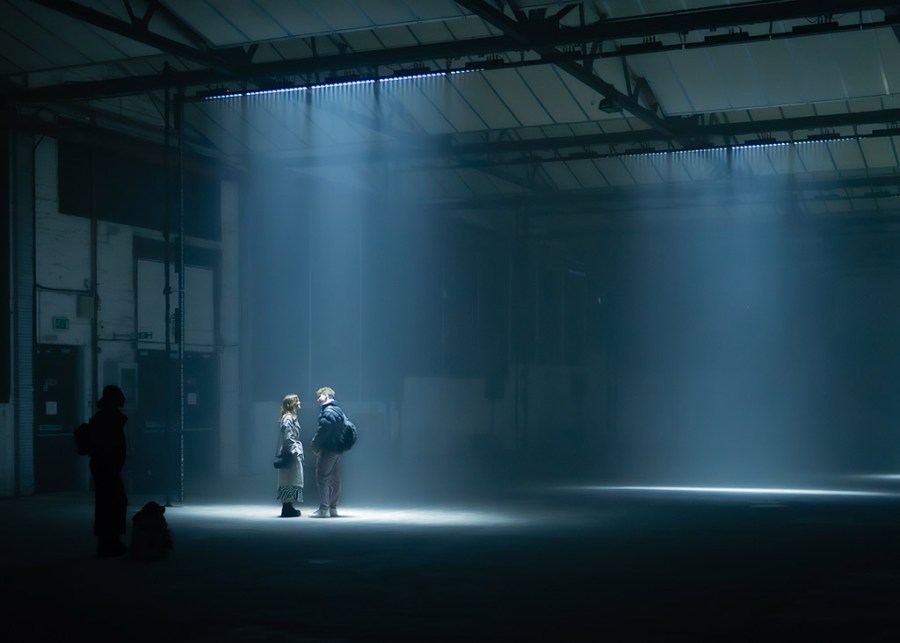 couple stood in spot light of low lit industrial building